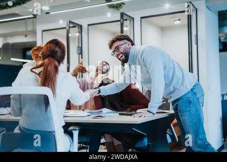 Overjoyed group of business colleagues celebrating success, victory or winning at modern office setting. They are overjoyed and laughing. Stock Photo