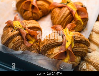 The Delicious bread placed on wooden shelves, these breads have exquisite shapes and are illuminated by warm lights. Stock Photo