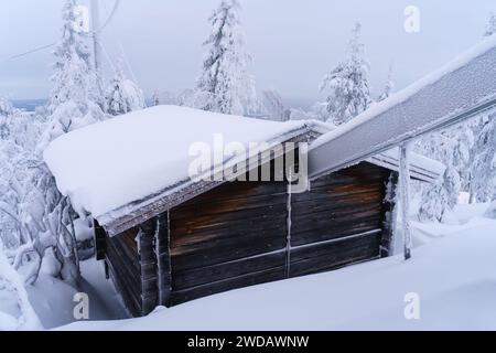 Snow covered log cabin up on the hill Stock Photo