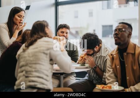 Diverse professionals having a lunch break, enjoying pizza and relaxing. Refreshing and refueling for a successful afternoon. Stock Photo