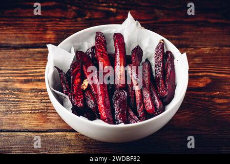 Oven baked beet fries in white bowl Stock Photo