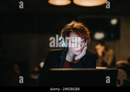 Stunning businesswoman analyzing market data for successful sales growth. Working late night, catching up on tasks for project deadline. Stock Photo