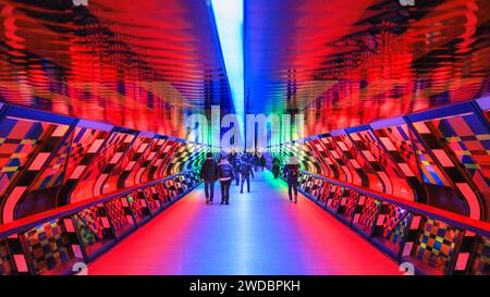London, UK. 19th Jan, 2024. People walk along, look at and take pictures of 'Captivated by Colour' by Camille Walala (France) on the Adams Plaza Bridge. The annual ‘Winter Lights' are spectacular free to see light installations and immersive art around Canary Wharf in East London. Credit: Imageplotter/Alamy Live News Stock Photo
