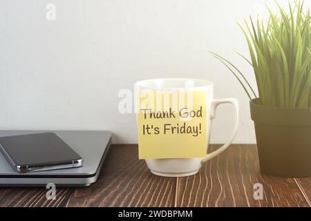 Thank God It's Friday on adhesive note stick on coffee cup Stock Photo