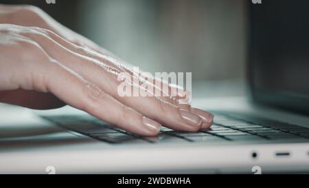 Typing hands white female. Close up of freelancer's developer hands typing program code on laptop keyboard. Businesswoman at work, working in office or at home. Business technology concept. Side view Stock Photo