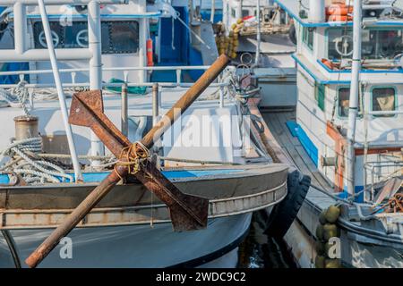 Large rusty iron anchor on bow of docked fishing trawler, South Korea, South Korea Stock Photo