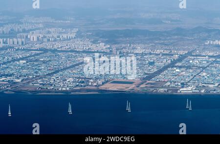 Cityscape and river seen from commercial aircraft in flight. Image is slightly blurred due to being taken through passenger window of airplane, South Stock Photo