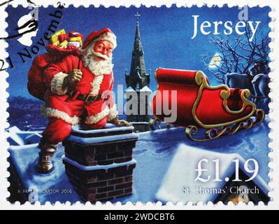 Santa Claus entering a chimney, on postage stamp Stock Photo