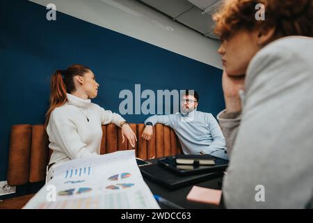 Business professionals collaborating in a creative office, analyzing stats and brainstorming ideas for business expansion. Stock Photo