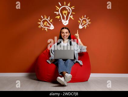 Idea generation. Woman with laptop in room. Illustrations of glowing light bulb over her Stock Photo