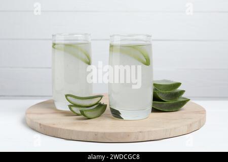 Tasty aloe juice in glasses and cut fresh leaves on white table Stock Photo