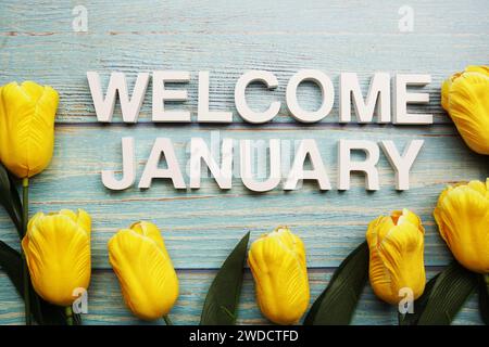 Welcome January alphabet letters with tulip flower on wooden background Stock Photo