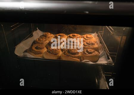 Cinnamon rolls buns baking in the oven. Stock Photo