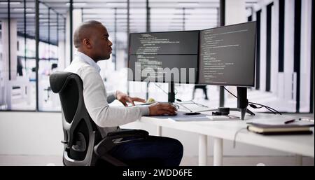 African American Coder Using Computer At Desk. Web Developer Stock Photo