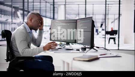 Unhappy Sad Developer Programmer Man In Stress Coding Software On Computer Stock Photo