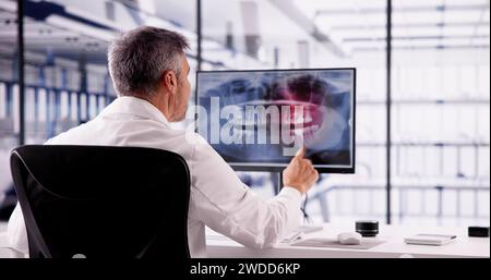 Dentist Doctor Looking At Teeth Xray On Computer Stock Photo