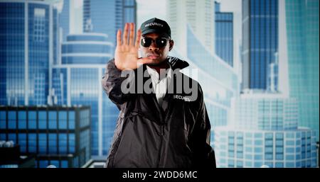 Security Guard In Uniform And Face Mask Making Stop Hand Gesture Stock Photo