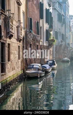 Small motor boats moored in a small canal in Venice Italy Stock Photo