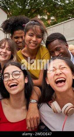 Vertical selfie young group excited students looking at camera laughing. Happy to be back at school. Stock Photo