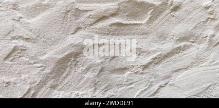 The rough texture of a poorly plastered light-colored wall. An uneven surface with bumps and depressions. Background for the design. Full frame. Copy Stock Photo