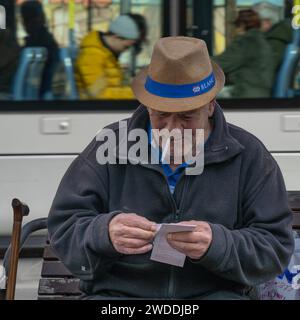 Jerusalem,. Israel - January 5th, 2023: An elderly man checking his lottery tickets on a Jerusalem, Israel, street. Stock Photo