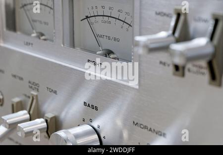 Old vintage stereo amplifier, aluminium front panel with knobs, buttons, dials and switches, close-up shot Stock Photo