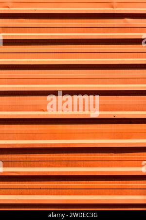 Orange corrugated metal plate surrounding wasteland Stock Photo