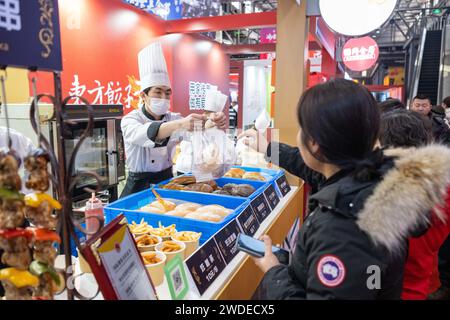 Harbin, China's Heilongjiang Province. 20th Jan, 2024. Tourists buy food during a food festival in Harbin, northeast China's Heilongjiang Province, Jan. 20, 2024. Credit: Xie Jianfei/Xinhua/Alamy Live News Stock Photo