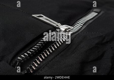 Metal zipper on a black background, close-up Stock Photo