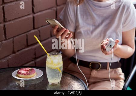 Freelancer's toolkit a powerbank in hand for uninterrupted remote work sessions Stock Photo