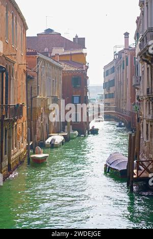 Venice colorful corners with iron bridges, old buildings and architecture, boats and beautiful water reflections on narrow canal, Italy Stock Photo