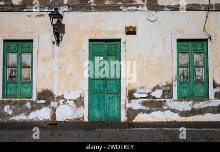 Crumbling decayed whitewashed walls with the typical Green Doors and windows. Stock Photo