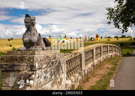 UK, England, Warwickshire, Compton Verney House, sphinx figure on Upper Bridge and Morag Myerscough’s, Summer of Sculpture colourful Village installat Stock Photo