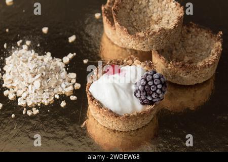 Homemade recipe made with oat flakes and natural yogurt filling, berries. Delicious and healthy breakfast snack preparation Stock Photo