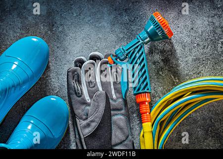 Gloves Hose Water Gun And Rubber Boots Garden Tools On Dark Background Stock Photo