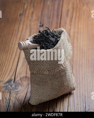 dragon black tea in canvas bag on wooden background Stock Photo