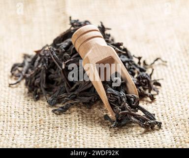 black tea leaves in wooden spoon on a canvas Stock Photo