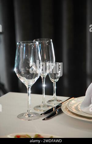 Table setting in a restaurant. Table setting with glasses, cutlery and plates. Restaurant interior. Stock Photo