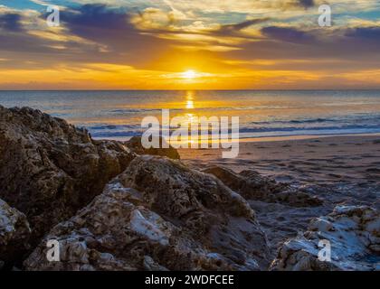 Golden sunrise over a rugged coastline, perfect for inspirational themes, travel promotion, and natural landscape photography. Stock Photo