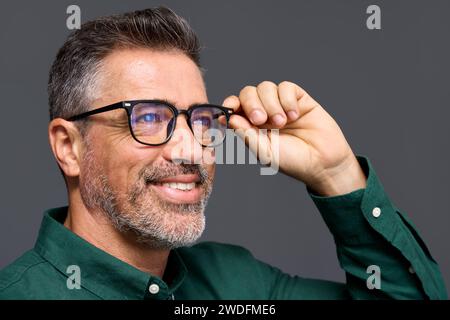 Smiling mature business man wearing stylish eyeglasses isolated on grey. Stock Photo