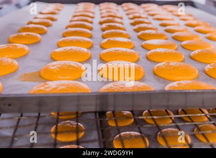 Orange cookies on white paper cooling on aluminum cookie sheet Stock Photo