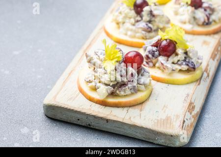 Waldorf salad with copy space. American fruit and nut salad with apples, celery, grapes, chicken meat, dressed mayonnaise. Stock Photo