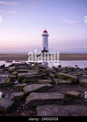 Old ruined causeway remains leading to Point of Ayr Lighthouse on Talacre Beach at sunset with a low tide, Talacre, Flintshire, Wales Stock Photo
