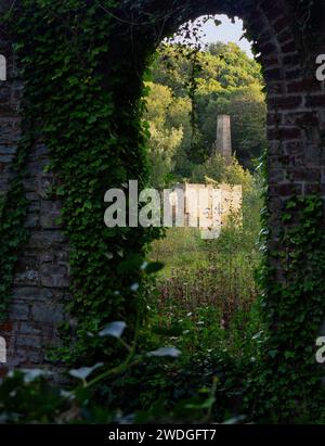 A view through a brick wall of Greenfield abandoned mill and battery works, Greenfield Valley Heritage Park, Holywell, Flintshire, Wales Stock Photo