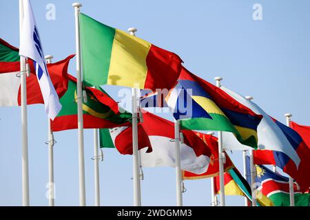 Group of flags of many different nations against blue sky Stock Photo