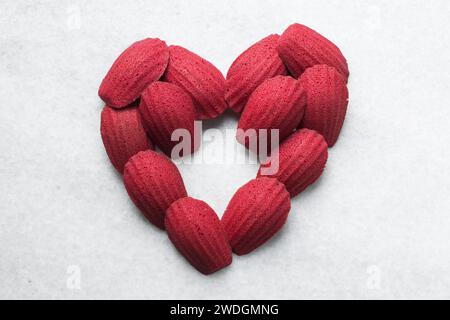 Red velvet madeleines on a marble tray shaped like a heart, red madeleines cake or cookies for valentines Stock Photo
