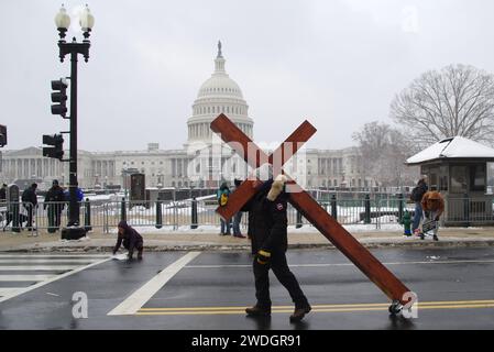 Washington, DC, USA. 19 Jan 2024. A man carries a large wooden cross near the U.S. Capitol during the annual anti-abortion March for Life rally. Stock Photo