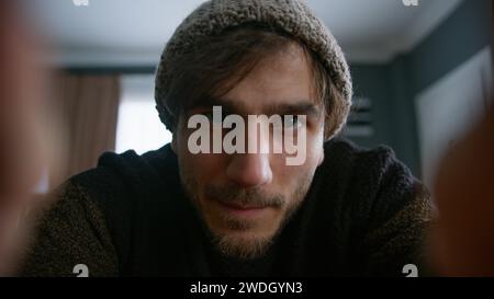 Young man with beanie vlogger doing online video chat call, record vlog blog talking to camera looking at webcam at home. Videocall and social media v Stock Photo