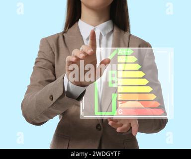 Energy efficiency. Woman with colorful rating against light background, closeup Stock Photo