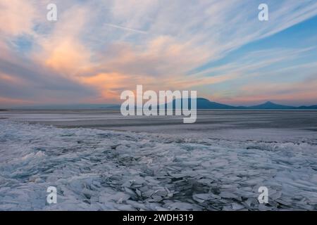 Aerial view of a frozen landscape at sunset with vibrant orange and red ...